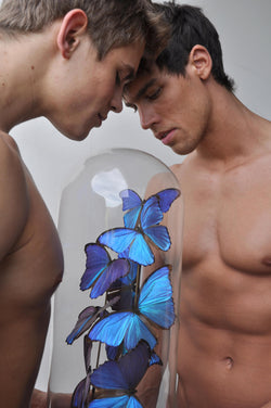 Ross Watson photograph of two naked Bel Ami models holding a cloche with blue butterflies under the glass dome.